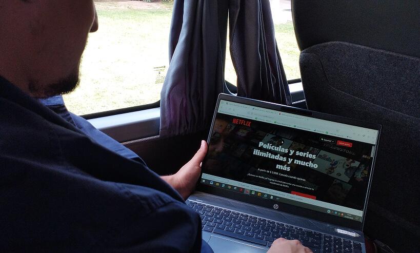 hombre viendo Netflix mientras viaja en autobús Andesmar